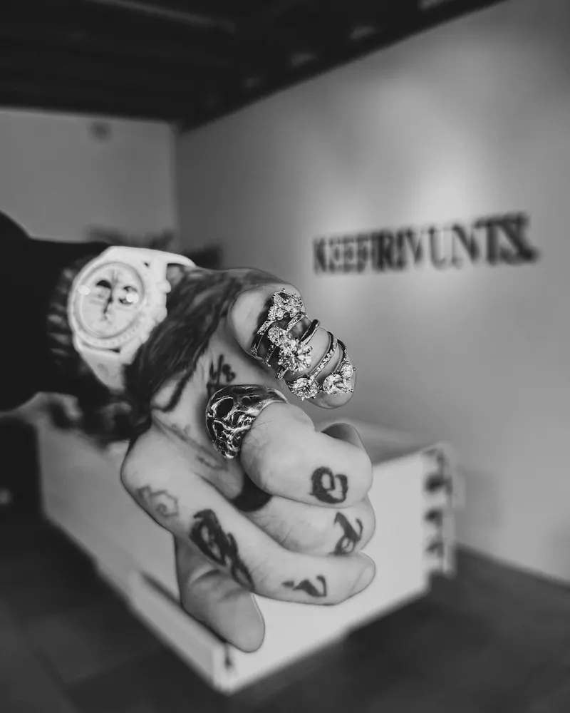 Rauno's tattooed hand holding rings